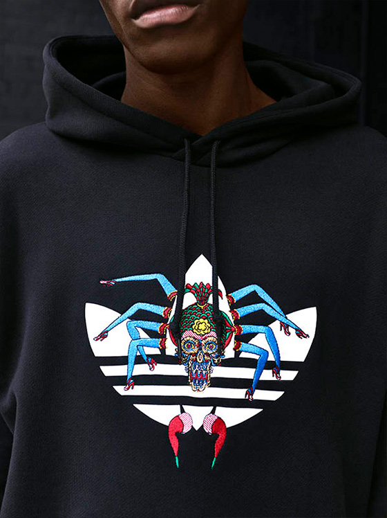 Close up of a Adidas x Tanaami hoodie with art on the logo.