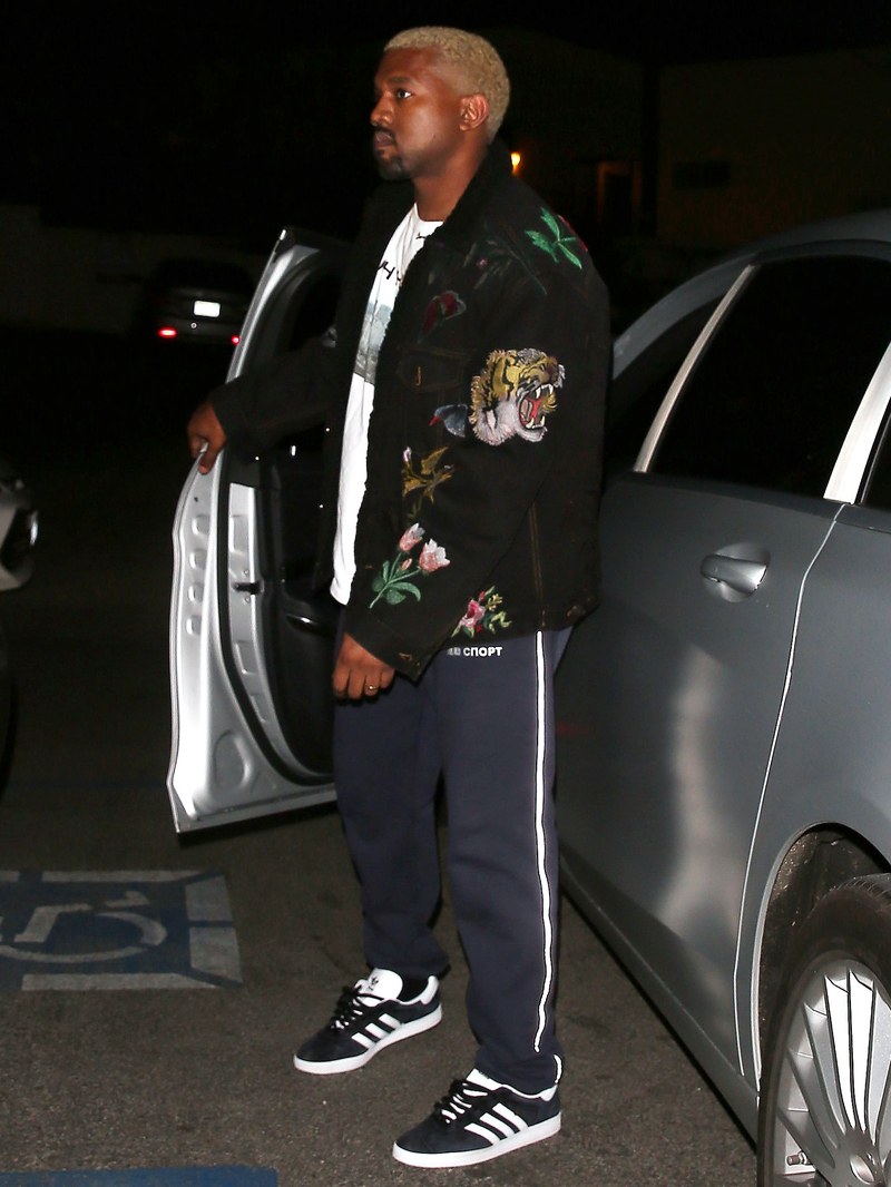 Kanye West Wearing adidas Originals trainers with blue tracksuit bottoms and a loud jacket