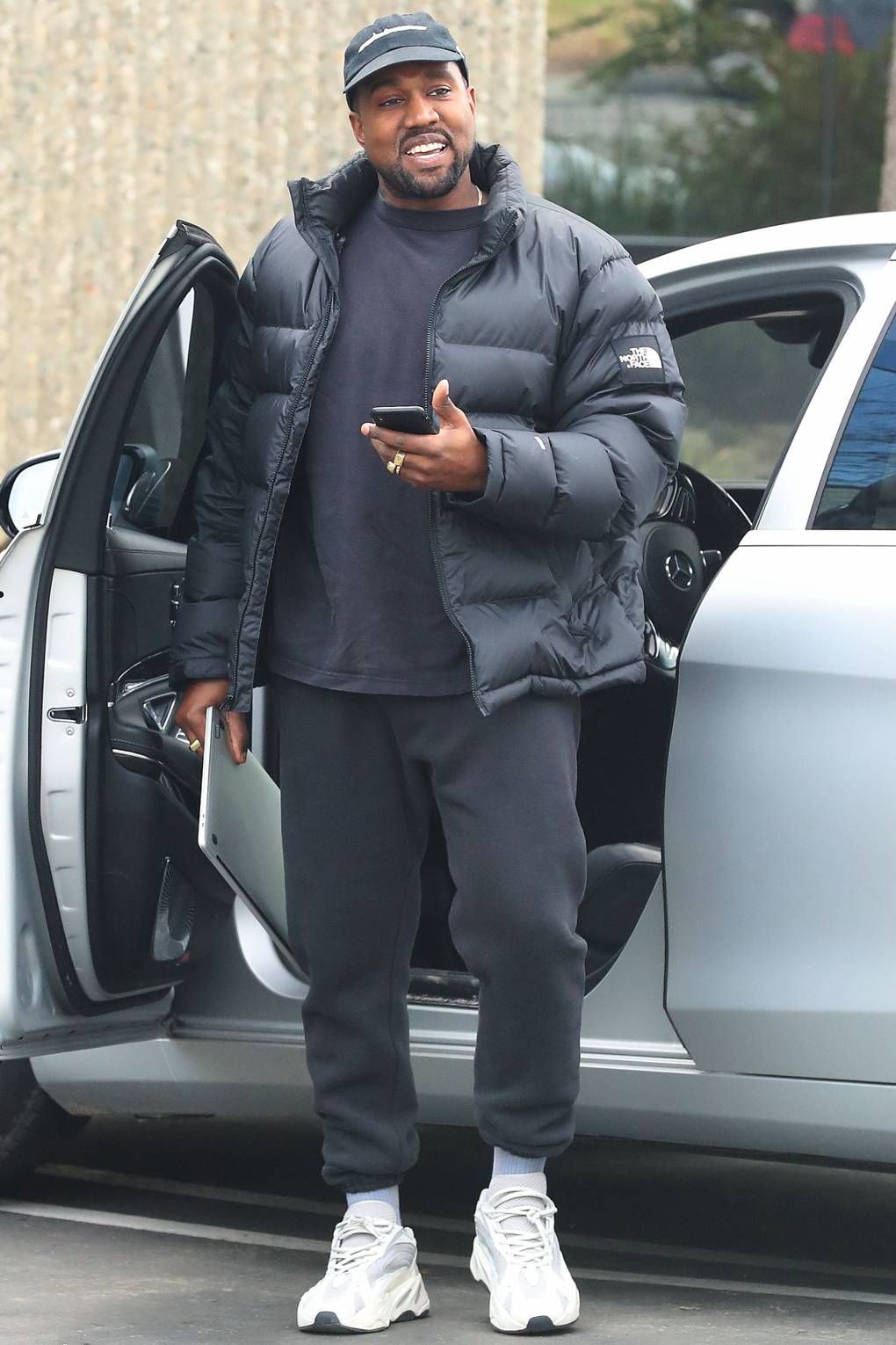 Kanye West Stepping out of a car and smiling. Wearing The North Face Jacket