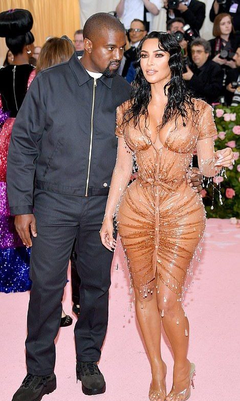 Kanye West at the Met Gala in an all black jacket trousers and trainers outfit, stood next to Kim Kardashian