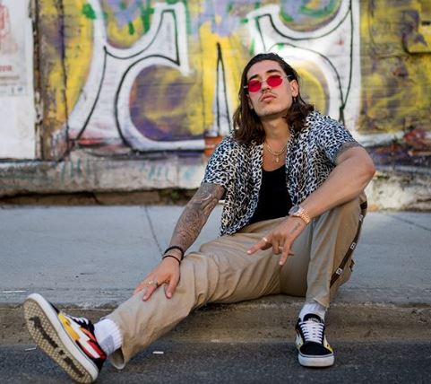 Hector wearing trousers and trainers